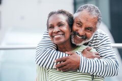 A smiling older black couple.