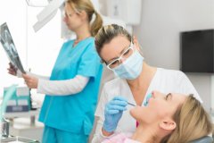 woman in the dentist chair gets examined for dental bondings
